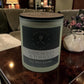 Candle labeled 'Dark Honey & Tobacco' on a table with a blurred background