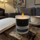 Candle labeled 'Dark Honey & Tobacco' on a wooden table with a book and cup in the background.
