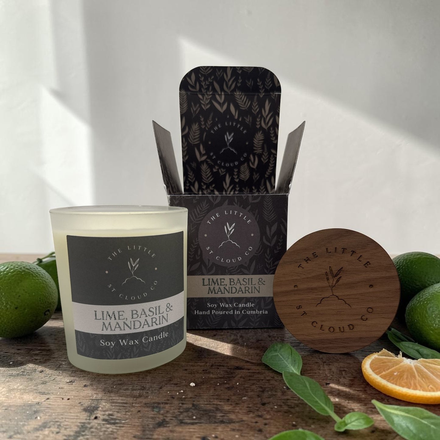 Soy wax candle with packaging and natural elements on a wooden surface