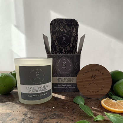 Soy wax candle with packaging and natural elements on a wooden surface