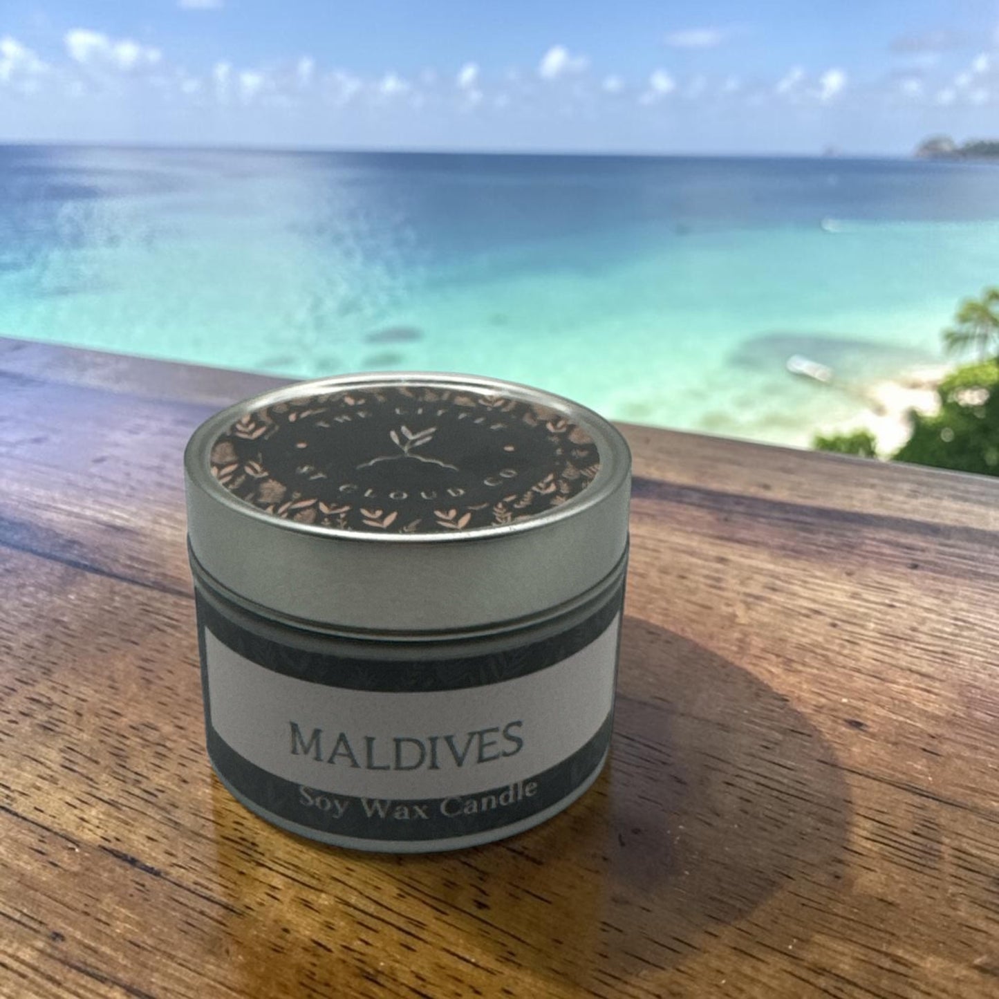 Candle tin in fragrance Maldives with a background of blue seas and white sandy beach