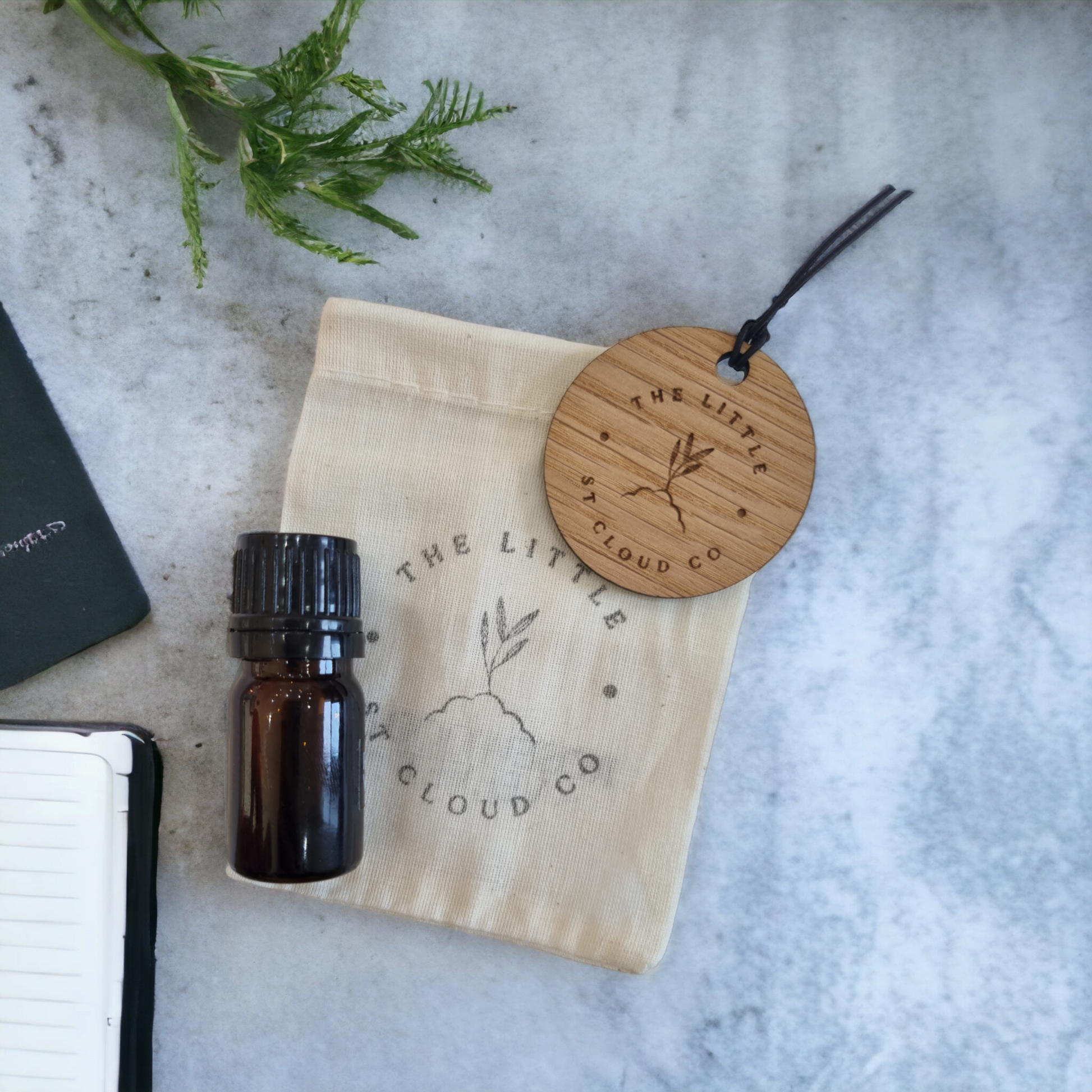 Wooden air freshener on a cotton bag with an amber bottle of fragrance oil